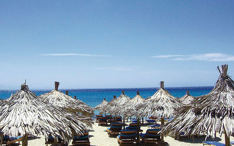 ein Bild eines Strandes auf Mykonos mit Blick auf Sonnenschirme und das Meer