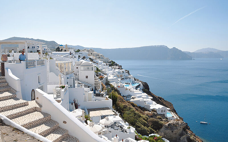 ein Bild des Ortes Oia auf Santorin mit weißen Gebäuden und Blick auf das Meer