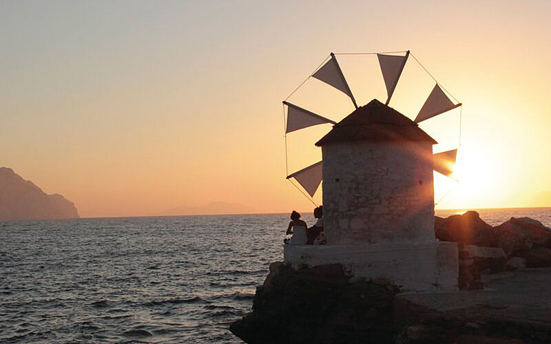 ein Bild von Amorgos mit einer Windmühle bei Sonnenauf- oder untergang