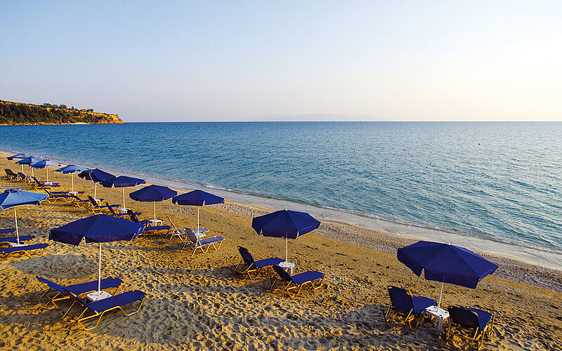 ein Bild mit Blick auf den Xi Strand auf Kefalonia mit Sonnenschirmen