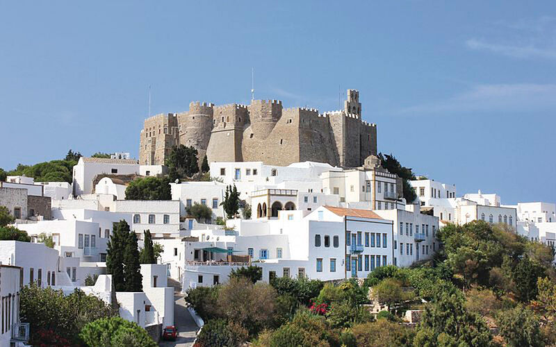 ein Bild mit Blick auf Monastery St. John auf Patmos und weißen Gebäuden im Vordergrund