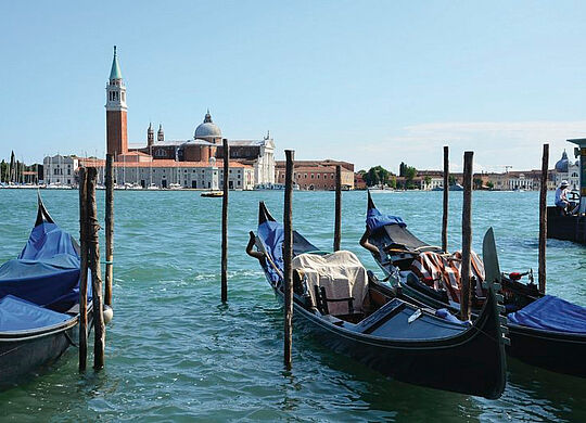 ein Bild von Venedig mit Booten und dem Meer mit Gebäuden im Hintergrund