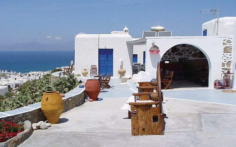 ein Bild von Mykonos mit Blick auf ein Gebäude und das Meer im Hintergrund