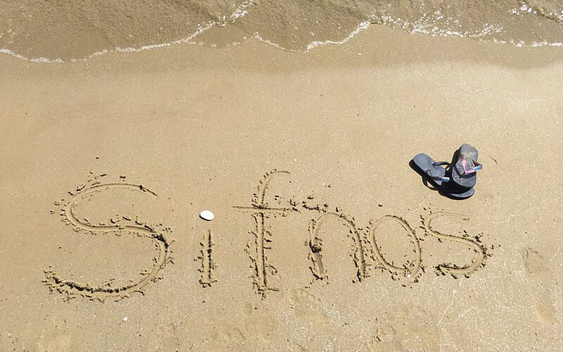 ein Bild eines Strandes auf Sifnos, auf dem "Sifnos" in den Sand geschrieben wurde