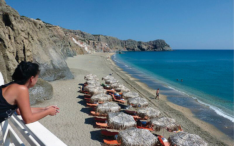 ein Bild des Paleochori Strandes auf Milos mit Sonnenschirmen und Blick auf das Meer