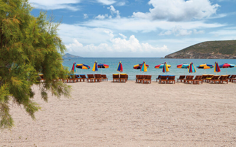 ein Bild von Panos Karapanagiotis auf Patmos mit Blick auf den Strand, Sonnenschirme, Liegestühle und das Meer