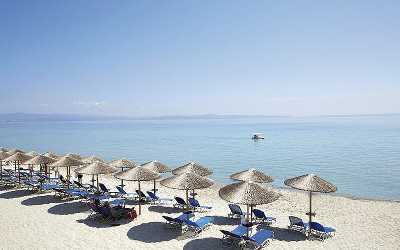 Chalkidiki, Hotel Ammon Zeus ein Bild eines Strandes auf Chalkidiki, der zu dem Hotel Ammon Zeus gehört, mit Sonnenschirmen, Liegestühlen und Blick auf das Meer