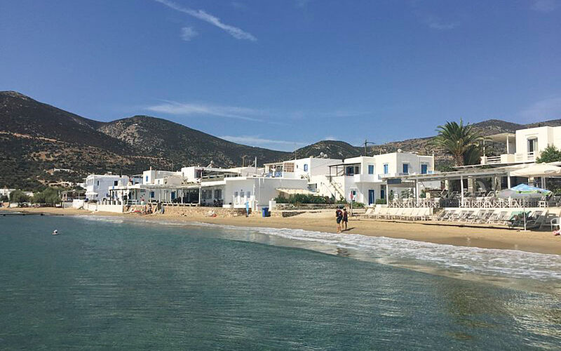 ein Bild des Platis Gialos Strandes auf Sifnos mit Blick auf weiße Gebäude