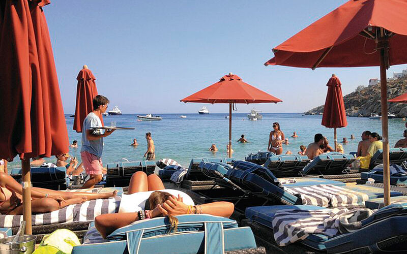 ein Bild des Nammos Strandes auf Mykonos mit Blick auf Sonnenschirme und das Meer